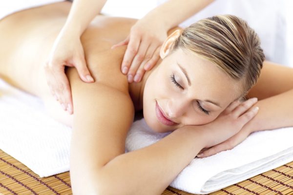 Relaxed smiling woman receiving a back massage Relaxed smiling woman receiving a back massage in a spa